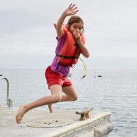 Emerald Bay- Girl has fun jumping off dock