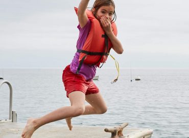 Emerald Bay- Girl has fun jumping off dock